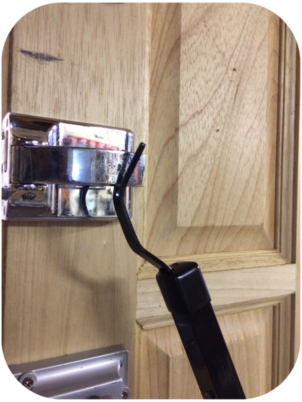 Black Locksmiths tool being used on a silver polished lock fitted to the inside of the door