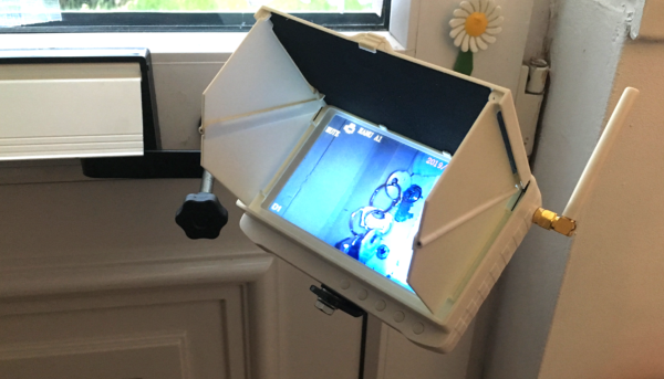 Inside of a door with Monitor bracket through the letterbox and white monitor with sunshade attached