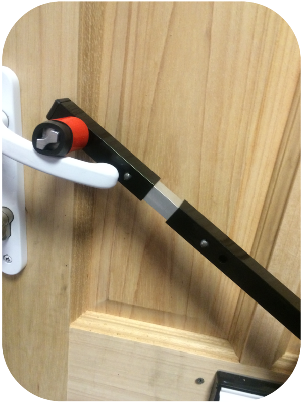 Locksmiths tool resting on white door handle