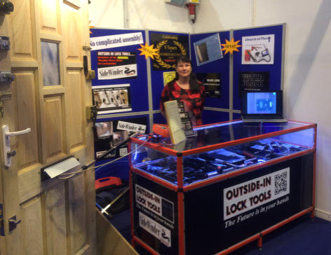 Wendy stands behind the counter at a Locksmiths trade Show stand for Outside-In Lock Tools Locksmiths tools